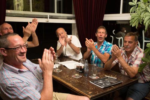 a group of men sitting at a table with their hands up at Hajo´s Germania Lodge & Irish Pub in Rüdesheim am Rhein