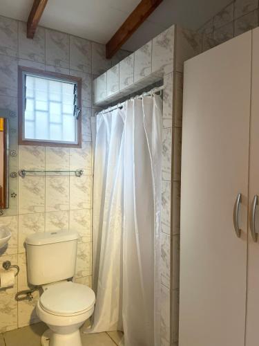 ein Bad mit einem WC und einem Duschvorhang in der Unterkunft Casa marejada in Caldera