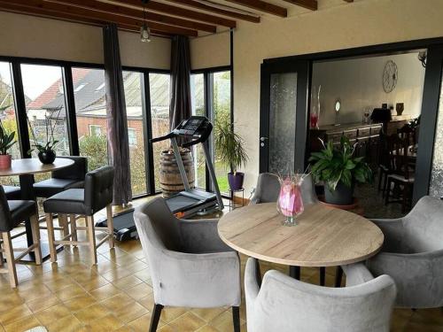 uma sala de jantar com mesa e cadeiras e um quarto com janelas em Villa LA DOLCE VITA 