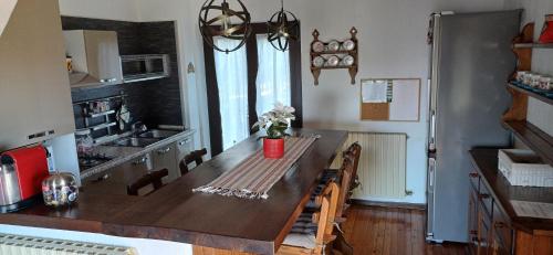 a kitchen with a wooden table with chairs and a counter top at Daniela's Home in Selvino