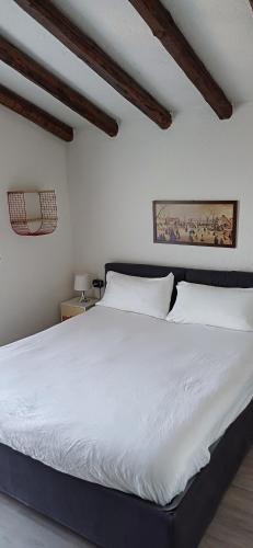um quarto com uma grande cama branca num quarto em Daniela's Home em Selvino