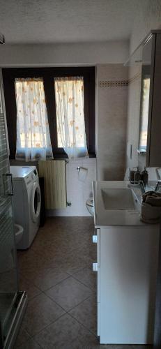 a kitchen with a sink and a washing machine at Daniela's Home in Selvino