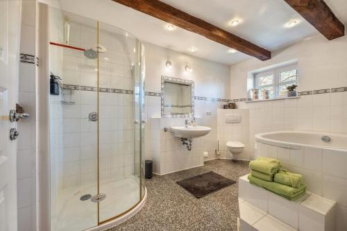 a bathroom with a shower and a tub and a sink at Ferienwohnung Juttashof in Camin