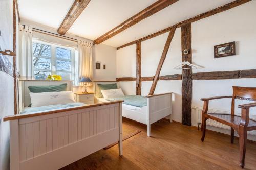 a bedroom with two beds and a chair at Ferienwohnung Juttashof in Camin