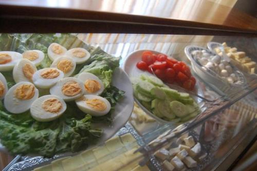 a plate of eggs and vegetables on a glass table at Hotel Irene in Lignano Sabbiadoro