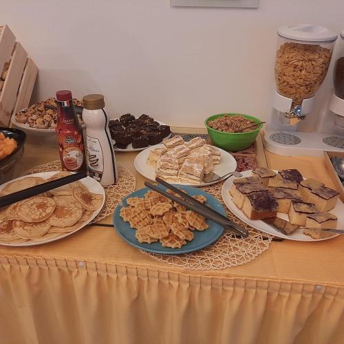 a table with plates of food on a table at Hotel Irene in Lignano Sabbiadoro