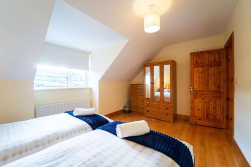 a bedroom with two beds and a window at Cluain Dara House in Dingle