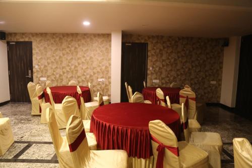 a room with tables and chairs with red table cloth at Suryaansh in Pālghar