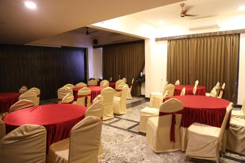 a room with red and white tables and chairs at Suryaansh in Pālghar