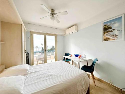 a bedroom with a bed and a table with a chair at Le Dulys : Apt 2 prs, vue mer, clim, 2 min plages in Antibes