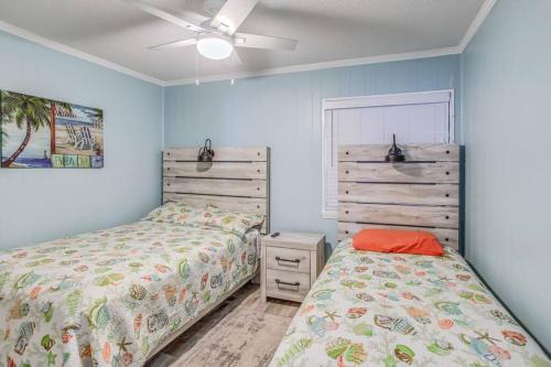 2 camas en un dormitorio con paredes azules en First Floor with Ground Floor Access - Steps to the Beach!, en Myrtle Beach