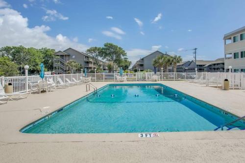 einen Pool in einem Resort mit Stühlen in der Unterkunft First Floor with Ground Floor Access - Steps to the Beach! in Myrtle Beach