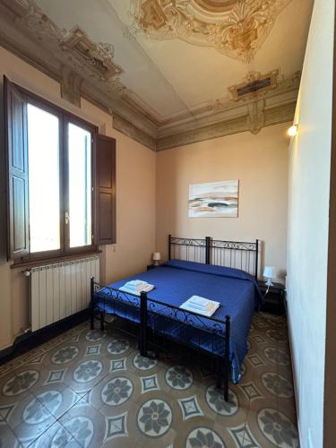 - une chambre avec un lit bleu et une fenêtre dans l'établissement VILLARTE, à Agliana