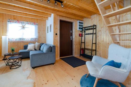 a living room with a blue couch and two chairs at Alpejskie domki Karkonosze in Jarkowice