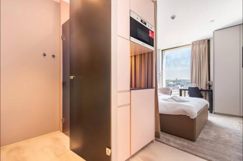 1 dormitorio pequeño con 1 cama y TV en Optimum Apartment - Opfikon en Opfikon