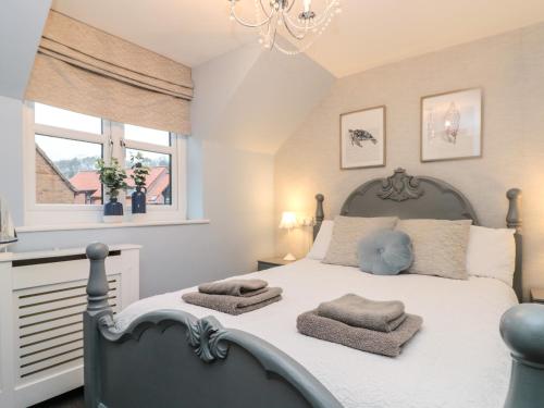 ein Schlafzimmer mit einem Bett mit zwei Handtüchern darauf in der Unterkunft Fauna's Corner in Whitby