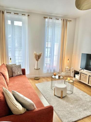un salon avec un canapé et une télévision dans l'établissement Appartement avec magnifique vue sur la Saône et son balcon, à Chalon-sur-Saône