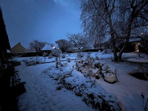 a garden covered in snow in a yard at La Romance et la Romanesque in Berville-sur-Mer