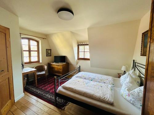 1 dormitorio con cama, escritorio y ventana en Alte Gerberei, en Bautzen