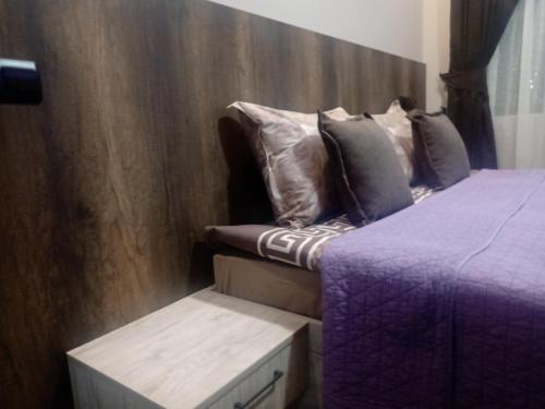 a bedroom with two beds and a wooden wall at КръчмЪ при Байката Alpin in Ribarica