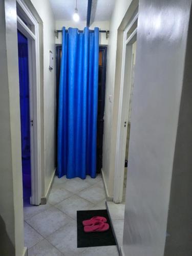- un couloir avec des rideaux bleus et un tapis noir dans l'établissement SIFRA HOMES, à Nairobi