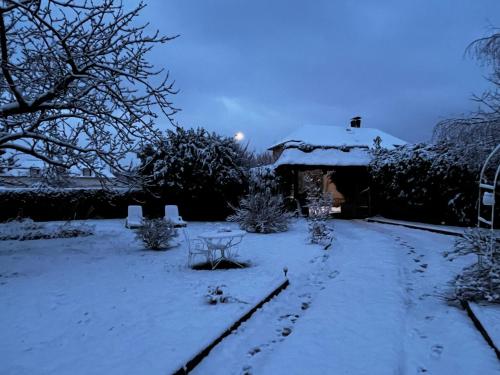 a yard covered in snow with a table at La Romance et la Romanesque in Berville-sur-Mer