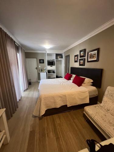 a bedroom with a large bed with red pillows at Milas Place in Somerset West