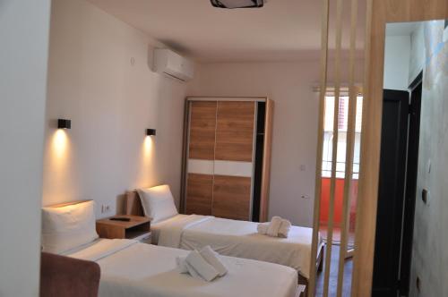 a hotel room with two beds and a mirror at Nego apartmani in Kuršumlija