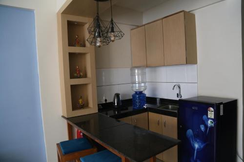 a kitchen with a black counter and a black refrigerator at Suryaansh in Pālghar