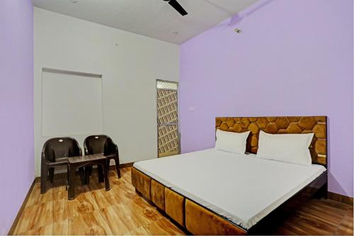- une chambre avec un grand lit et deux chaises dans l'établissement Super OYO New Paradise Guest House, 