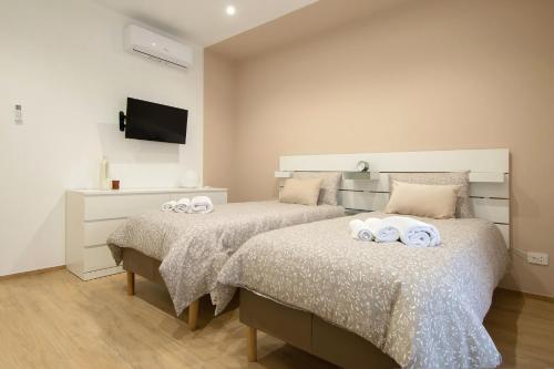 1 dormitorio con 2 camas y toallas. en Don Bi Apartments, en Trecate