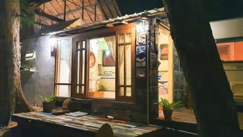 a window of a building with plants in it at Maliblues Bed & Art Gallery in Chumphon