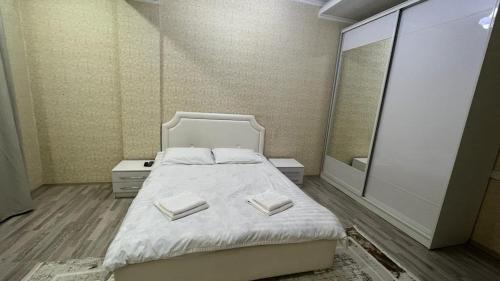 ein Schlafzimmer mit einem Bett und einem großen Spiegel in der Unterkunft Апарт отель Гок Таш in Bischkek