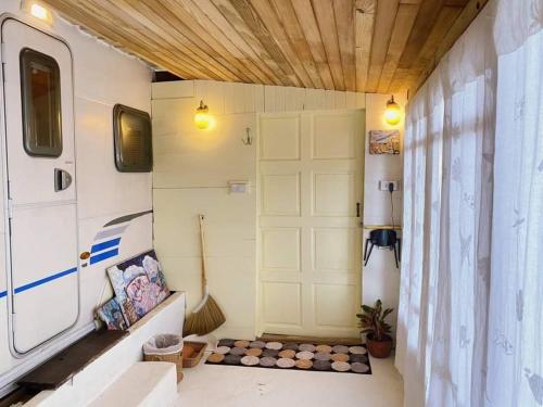 a room with a garage with a white door at Maliblues Bed & Art Gallery in Chumphon