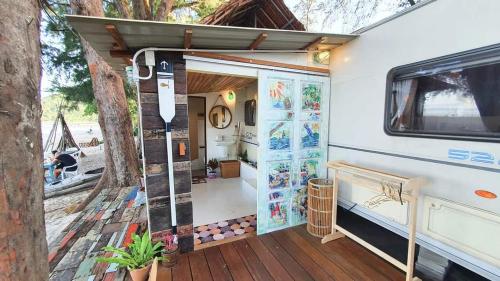 una puerta abierta de una caravana con porche en Maliblues Bed & Art Gallery en Chumphon