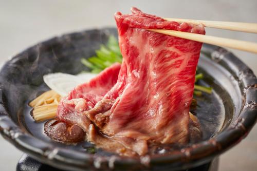 神戶的住宿－KAMENOI HOTEL Arima，盘子里放着肉和面食的食品