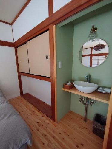 a bedroom with a sink and a mirror at そらやまゲストハウス Sorayama guesthouse in Ino