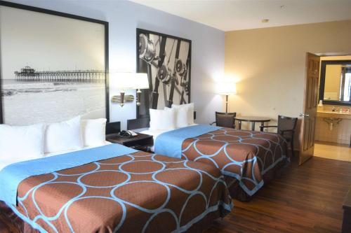 a hotel room with two beds and a large window at Super 8 by Wyndham Galveston in Galveston