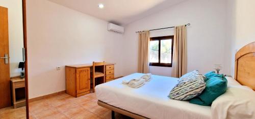 a bedroom with a bed and a desk and a window at Finca con piscina rodeada de naturaleza in Sencelles