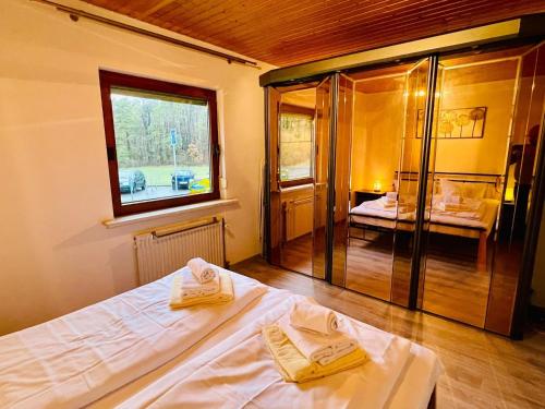 a bedroom with a bed with two towels on it at Bungalow am Fuße der Wasserkuppe in Dipperz