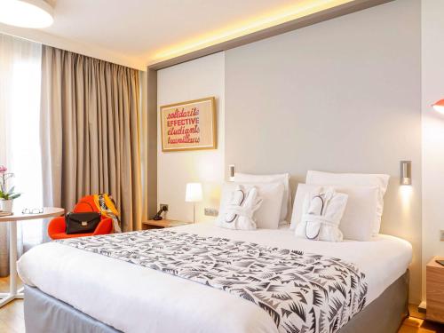 Habitación de hotel con cama grande con almohadas blancas en Mercure Marseille Centre Prado Vélodrome, en Marsella