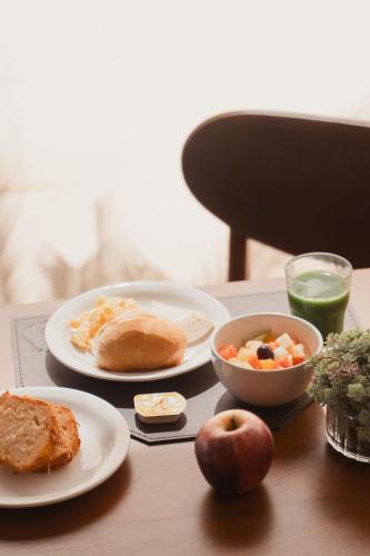 a table with plates of food and a bowl of fruit at Strassen Hotel in Goiânia