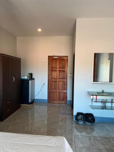 um quarto com uma porta de madeira e um lavatório em Nare Guest House em Ko Lanta