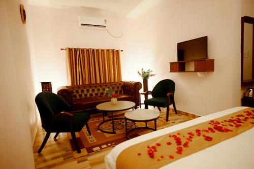 een kamer met een bed, een bank en een tafel bij hotel ustav in Bolpur