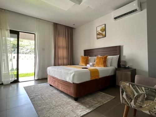 a bedroom with a large bed and a balcony at Epic Springs Bed & Breakfast in Jwaneng