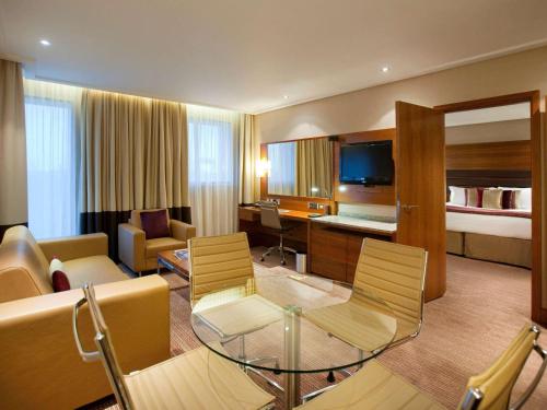 um quarto de hotel com um sofá e uma sala de estar em Sofitel London Heathrow em Hillingdon