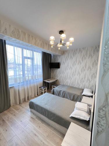 une chambre avec deux lits et un bureau dans l'établissement Отель-музей, à Tachkent