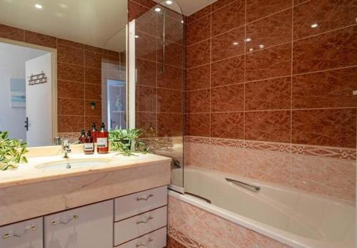 une salle de bain avec une baignoire, un lavabo et une douche dans l'établissement Heliodore - Appartement terrasse vue Bassin, à Arcachon