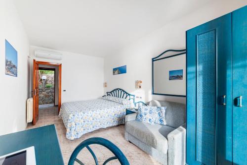 伊斯基亞的住宿－Punta Chiarito Resort，一间卧室配有一张床、一张沙发和一把椅子