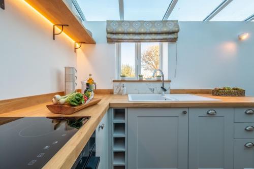 eine Küche mit einer Arbeitsplatte mit Spüle und Spülbecken in der Unterkunft Golf Cottage in West Runton